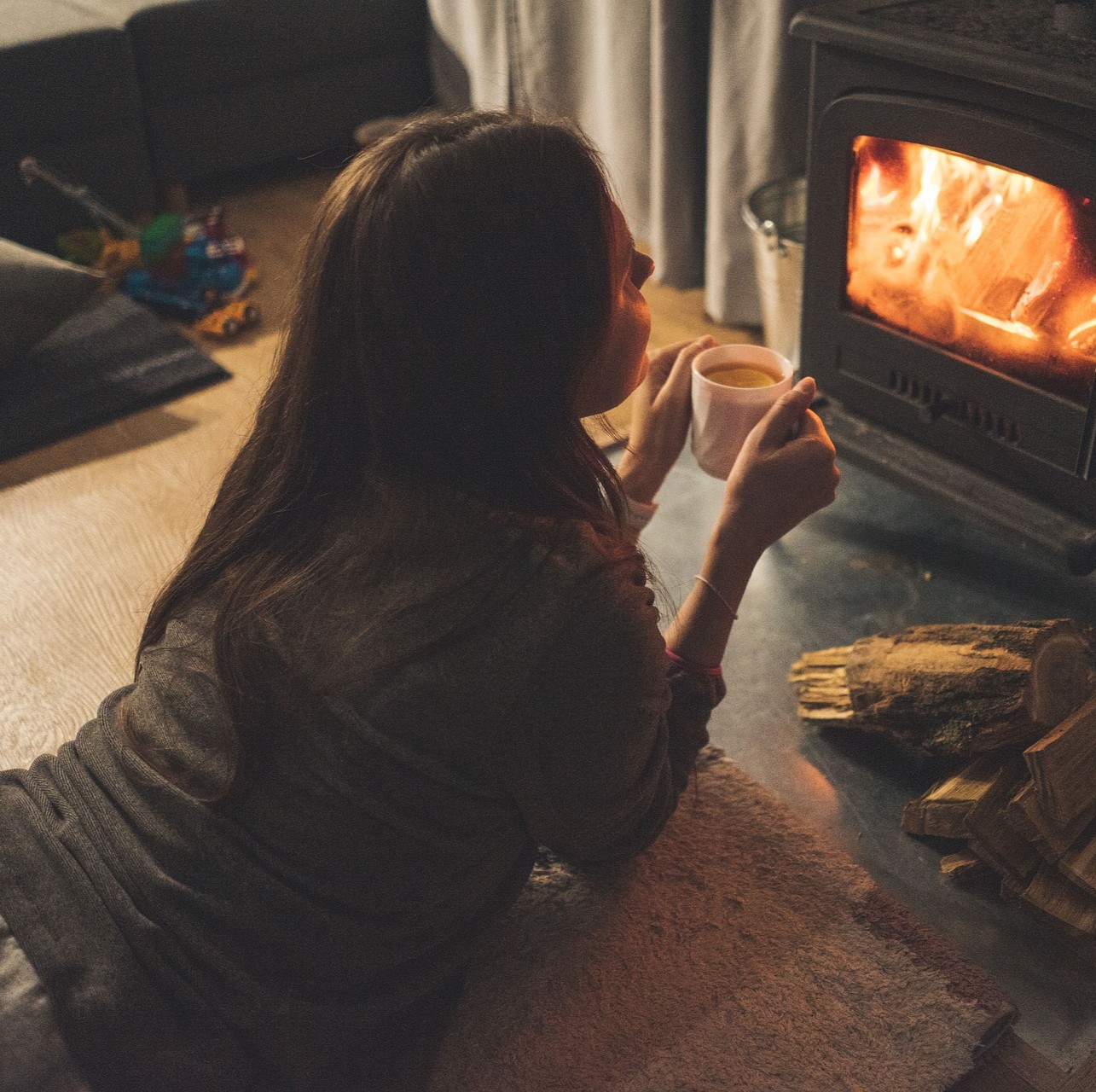 mujer disfrutando del calor de su estufa a pellets de Podero en el sur de chile